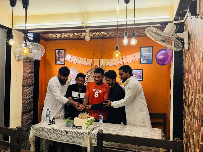 Friends cutting a birthday cake together at The Pahalgam